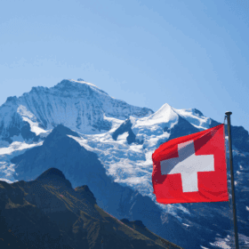 Bergpanorama der Schweizer Alpen mit Flagge, symbolisiert das neue Leben in der Schweiz.